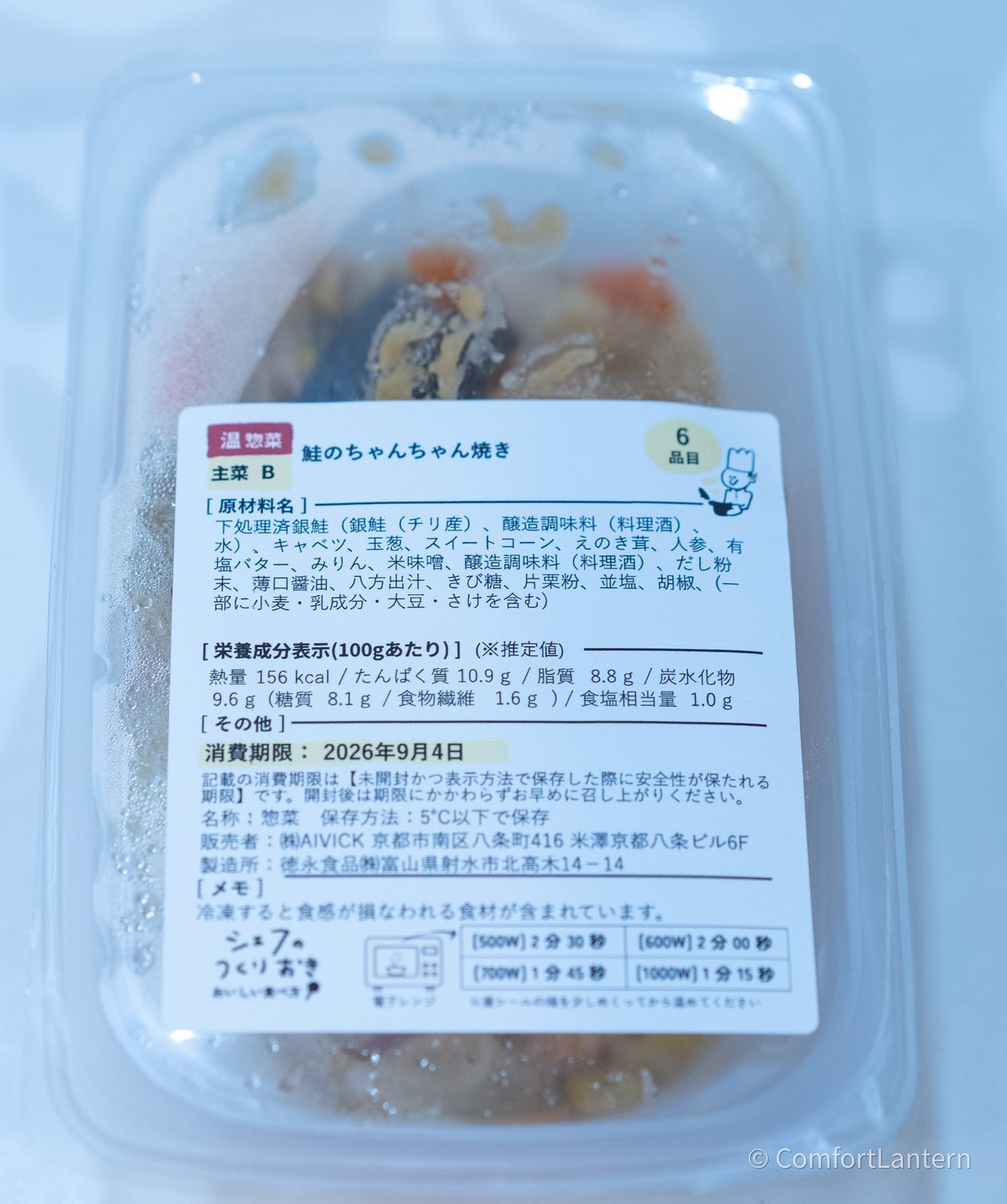 鮭のちゃんちゃん焼きの容器に貼られたラベル。原材料に下処理済銀鮭、キャベツ、玉葱、スイートコーン、えのき茸、人参などが並んでいる