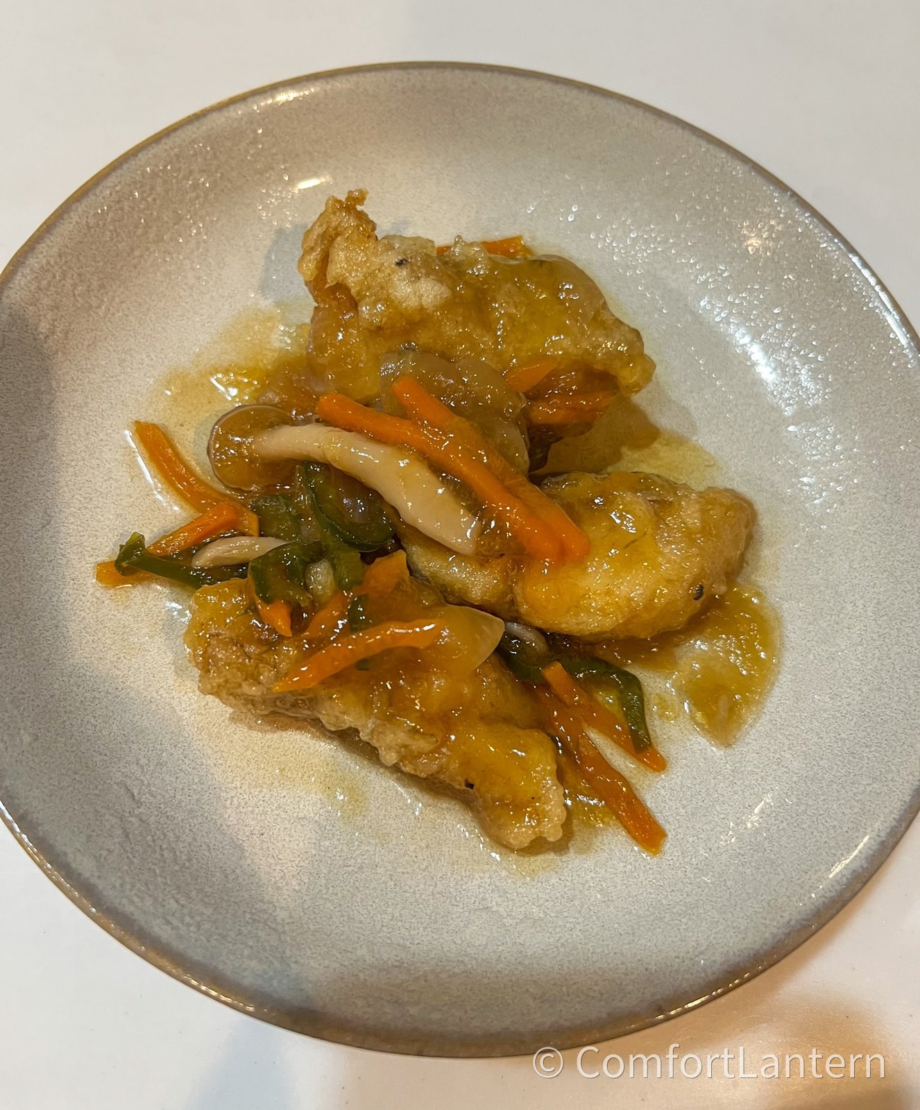 ふわ揚げ白身魚の野菜あんかけを取り分けた1皿目。灰色の皿に盛りつけてある