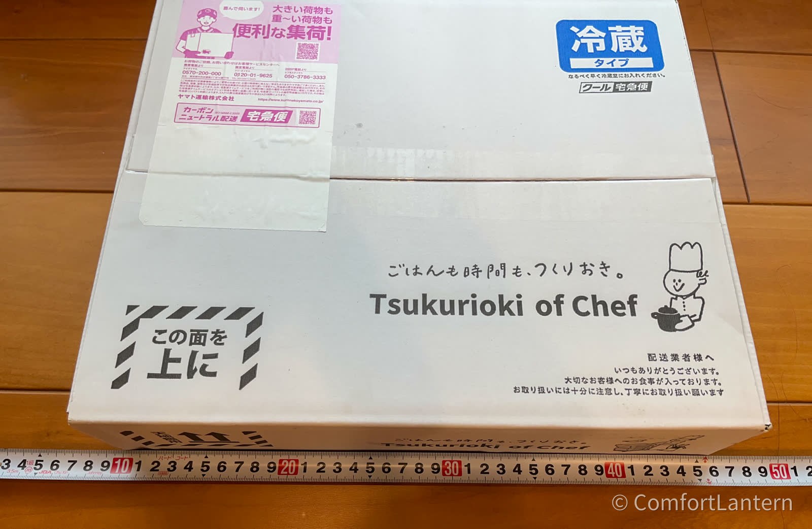 箱の横に定規を当てて大きさを測っている。長辺は40センチ強