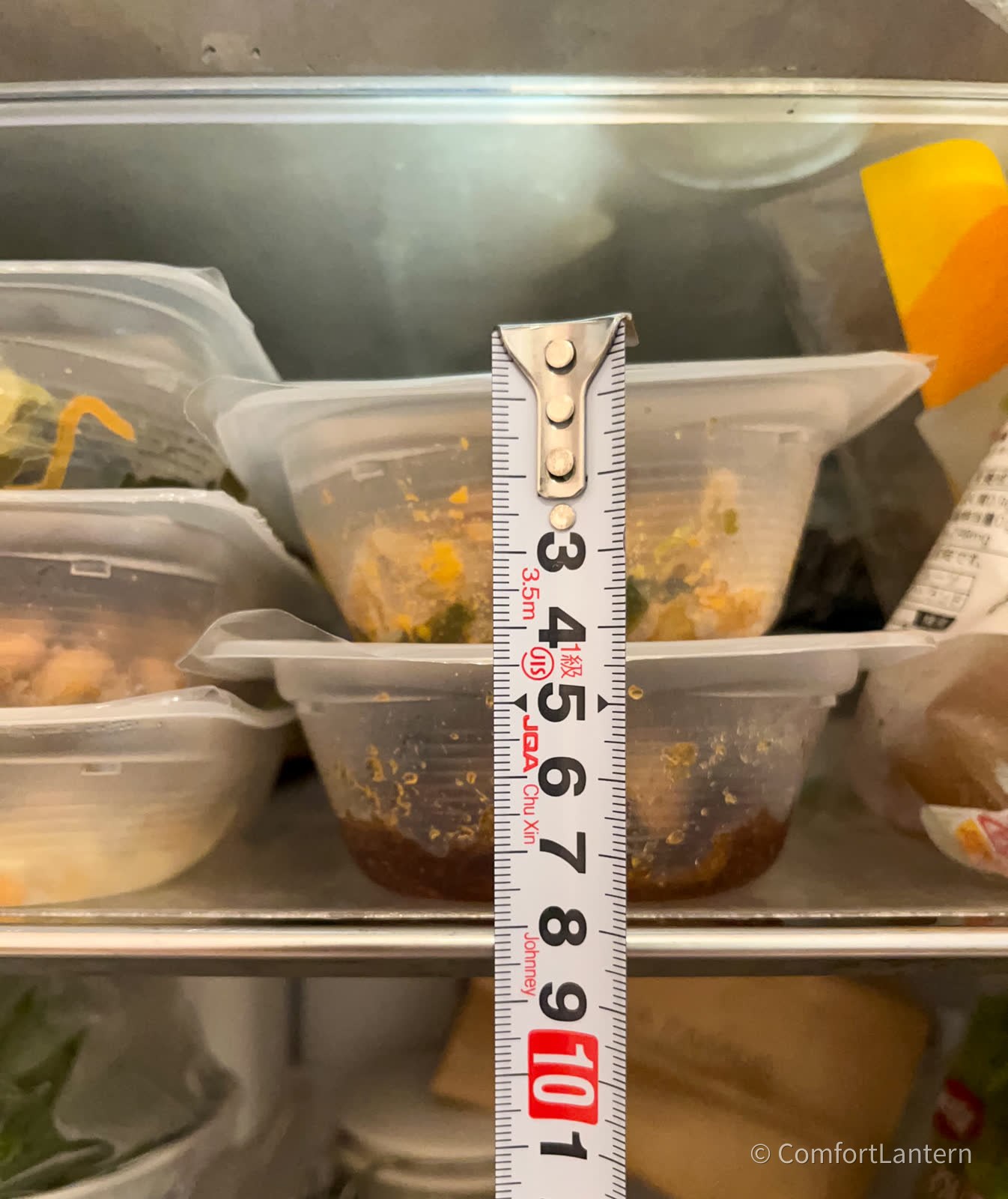 惣菜パックを2段に重ねた高さを定規で測っている。約8センチ