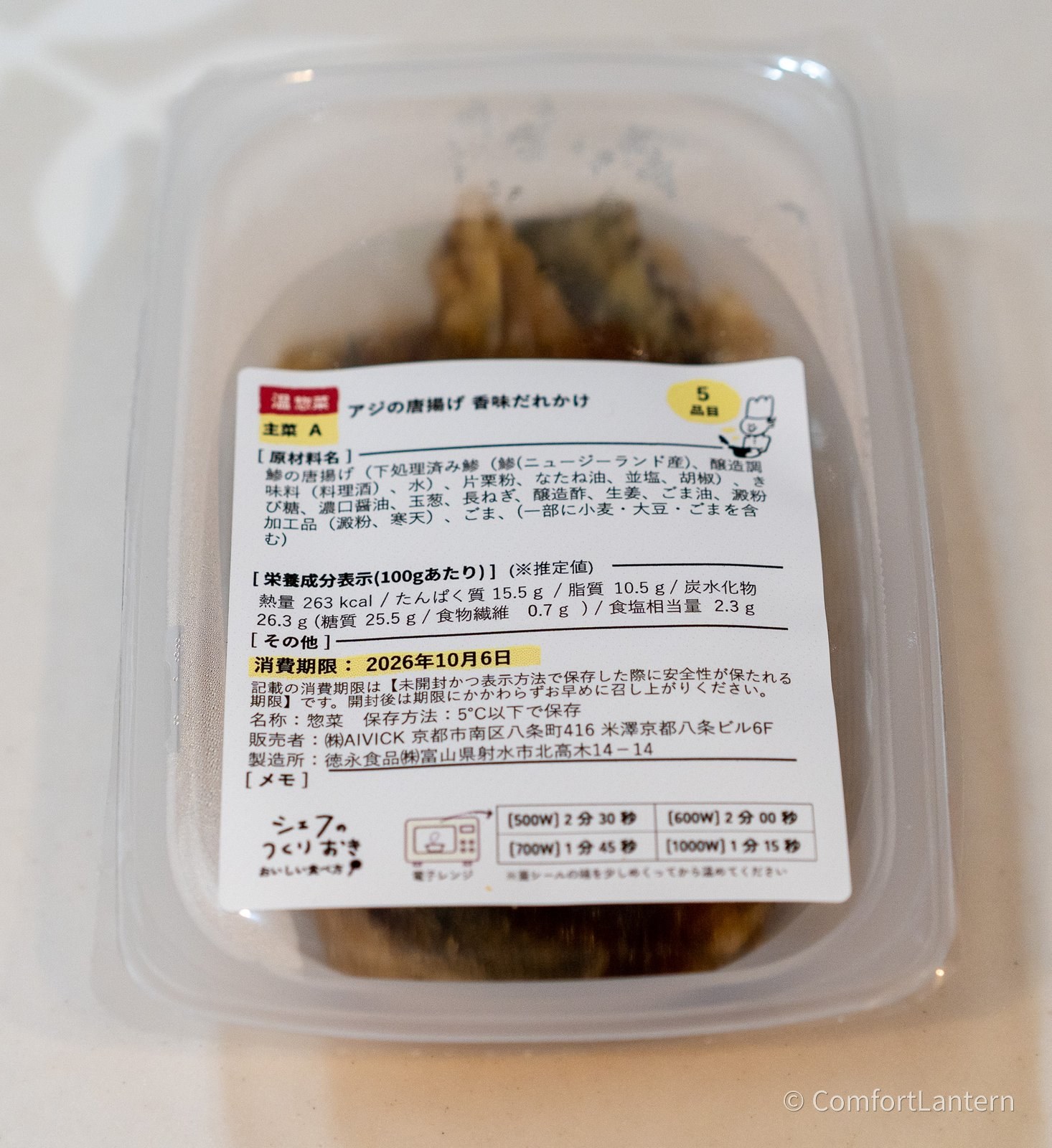 アジの唐揚げ 香味だれかけの容器に貼られたラベル。原材料に鯵の唐揚げ(ニュージーランド産)、長ねぎ、玉葱、生姜、ごまなどが並んでいる