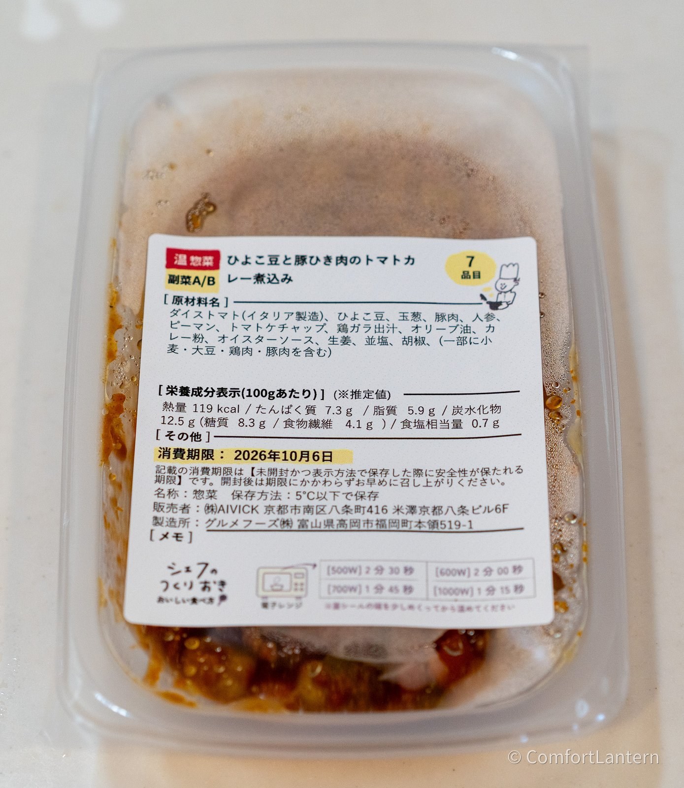 ひよこ豆と豚ひき肉のトマトカレー煮込みの容器に貼られたラベル。原材料にダイストマト、ひよこ豆、玉葱、豚肉、カレー粉などが並んでいる
