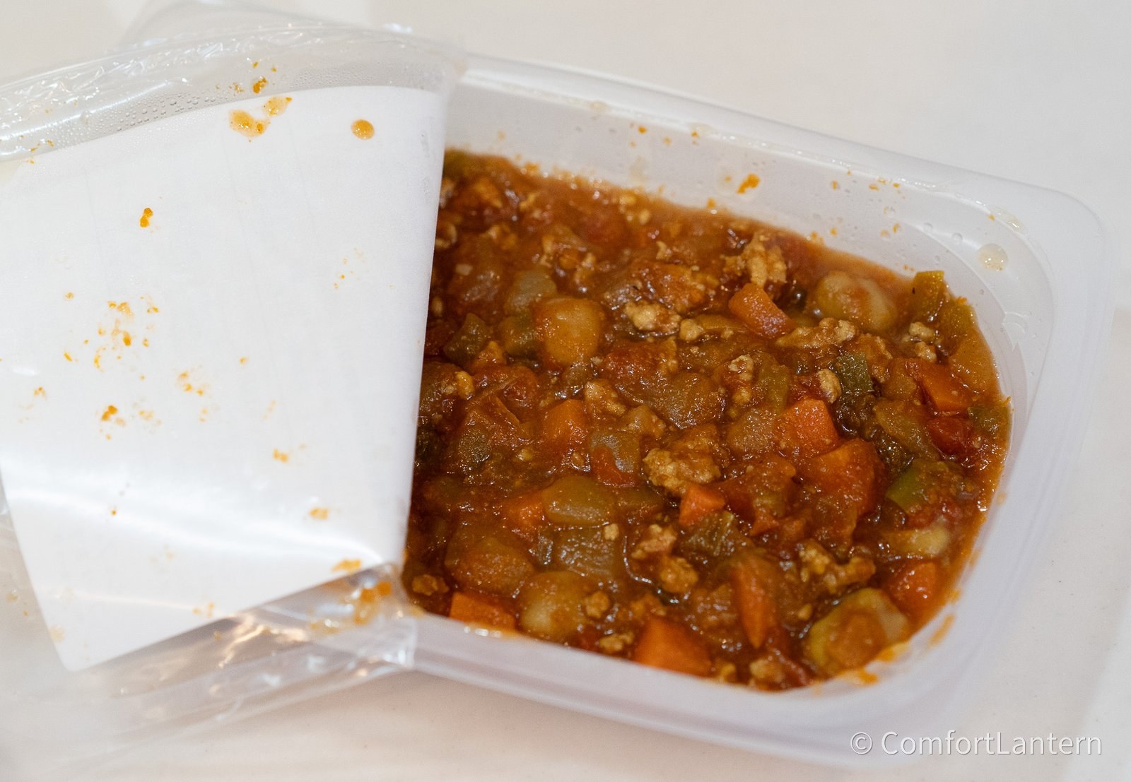 容器を開けたひよこ豆と豚ひき肉のトマトカレー煮込み。ひよこ豆と角切りの人参とひき肉がトマト色の煮込みに入っている