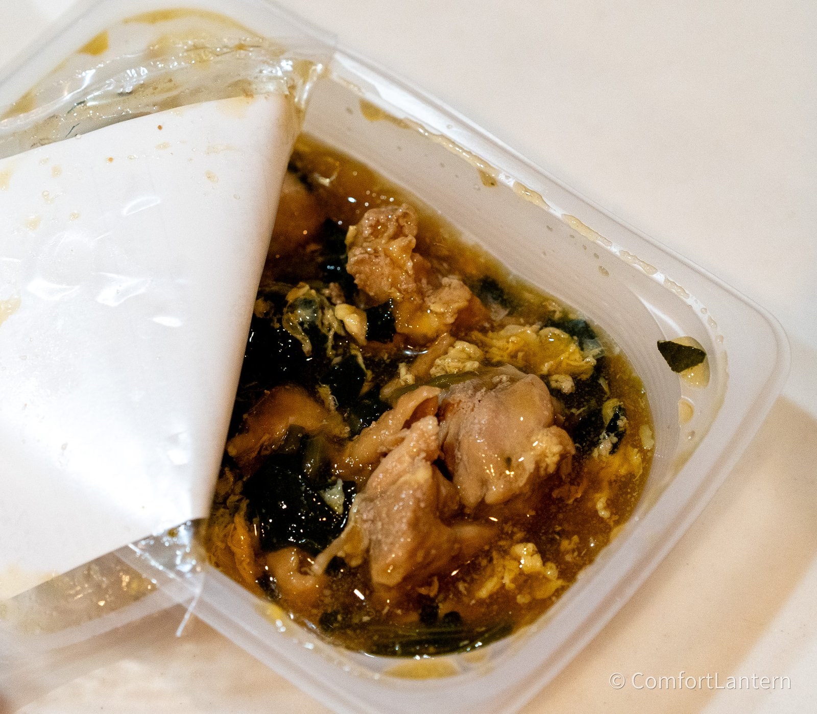 容器を開けたご飯に合わせたい親子煮。鶏肉と卵とほうれん草がとろみのあるつゆに入っている