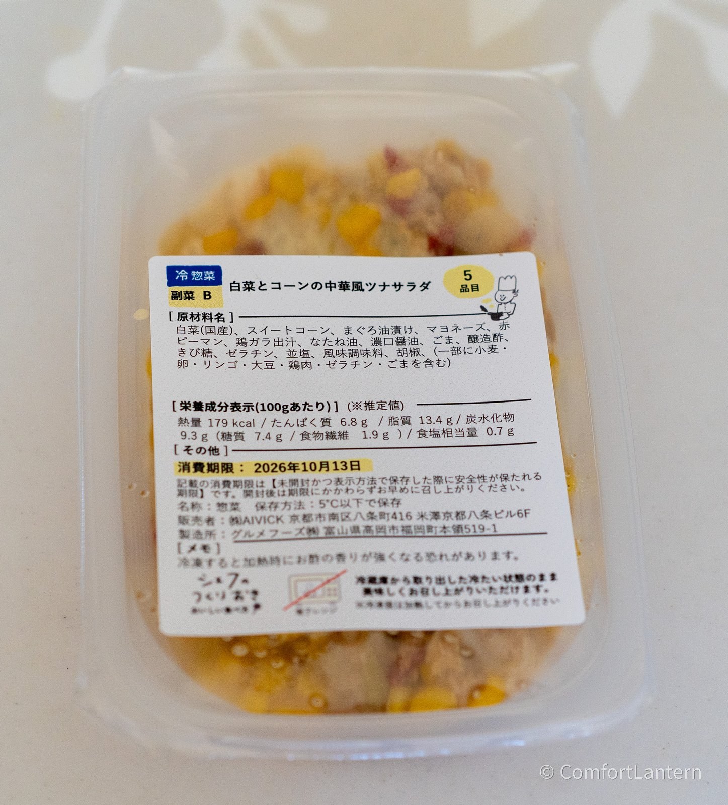 白菜とコーンの中華風ツナサラダの容器に貼られたラベル。原材料に白菜(国産)、スイートコーン、まぐろ油漬け、マヨネーズ、赤ピーマンなどが並んでいる