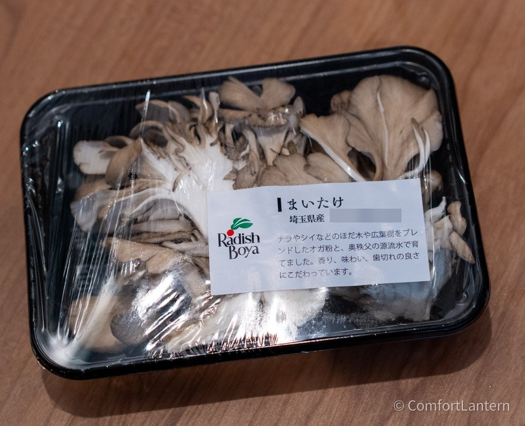黒いトレーに入ったまいたけ。ラベルが貼られている